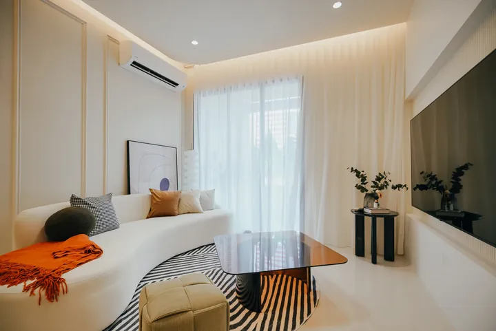 Show unit living room with a curved sofa at Aliva @ Mount Austin