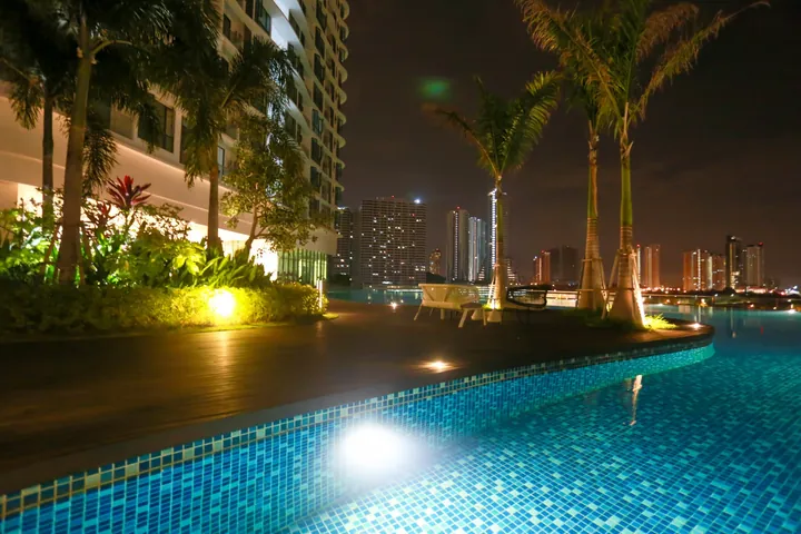 Podium pool at Macrolink Medini at night with the Medini skyline behind