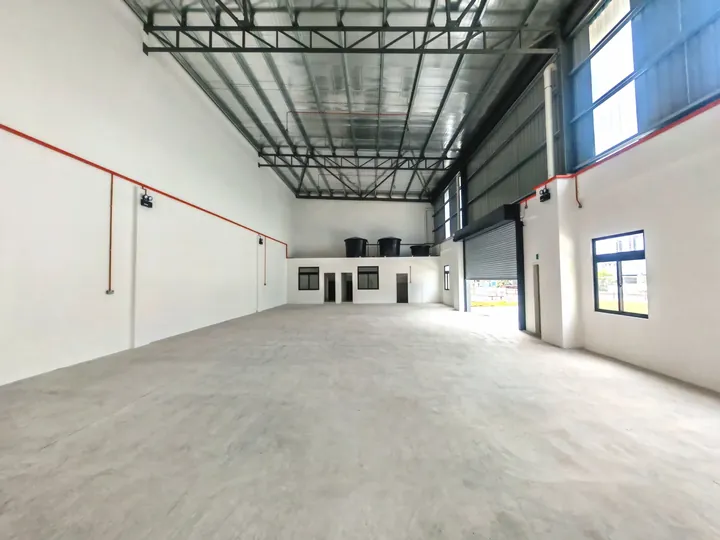 High-bay steel truss roof and hardener-finished floor inside a Setia Edge factory, photographed on site
