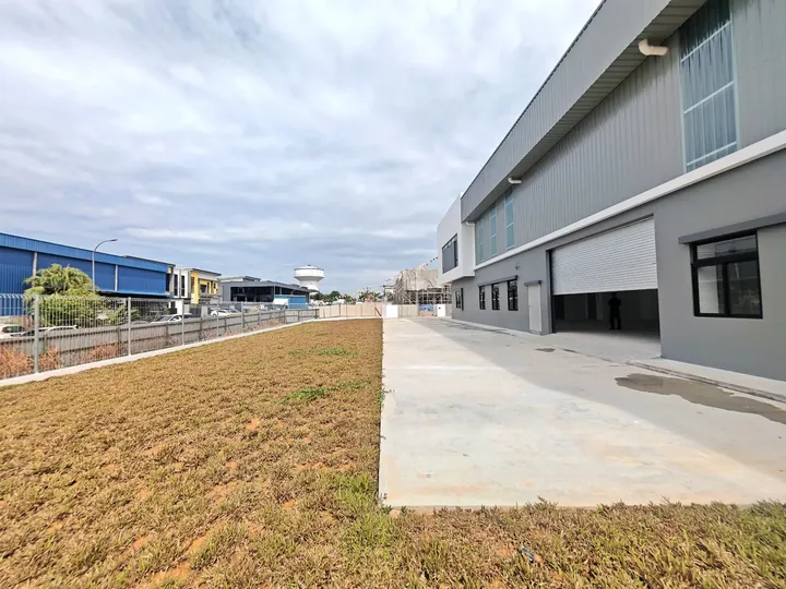 Concrete loading apron and roller shutter along the side of a factory at Setia Edge, photographed on site