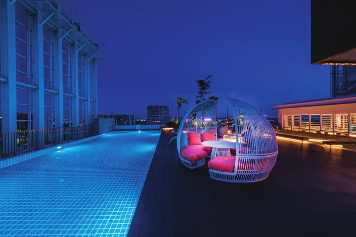 Level 34 sky pool at Suasana Iskandar at night with a rattan daybed