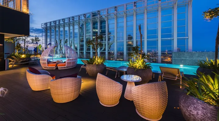 Sky deck and rattan seating beside the Level 34 pool at Suasana Iskandar at night